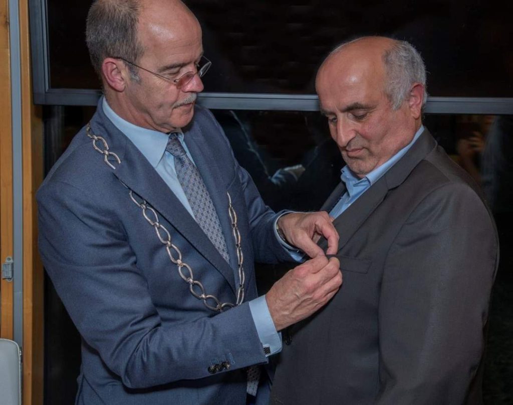 Burgemeester van Hedel spelt het lintje op bij Ihsan.